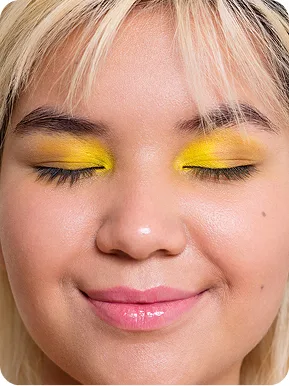 A close-up photo of a woman with yellow eye shadow.