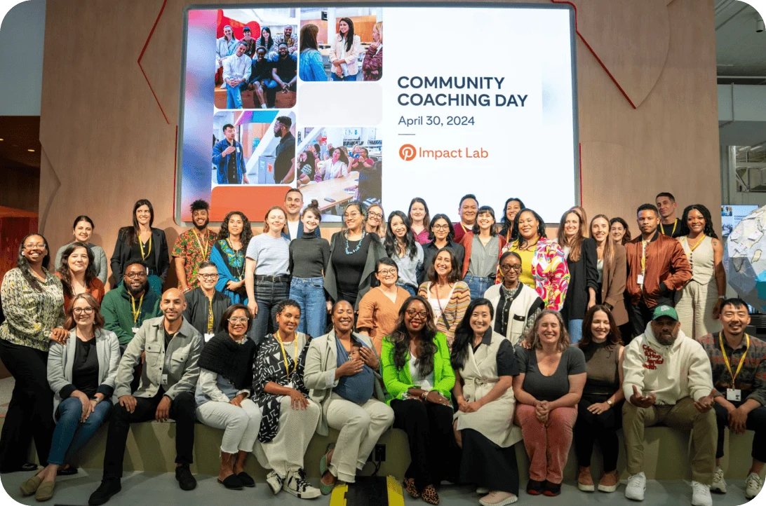 The Pinterest Impact Lab 2024 cohort takes a group photo in front of a projector screen