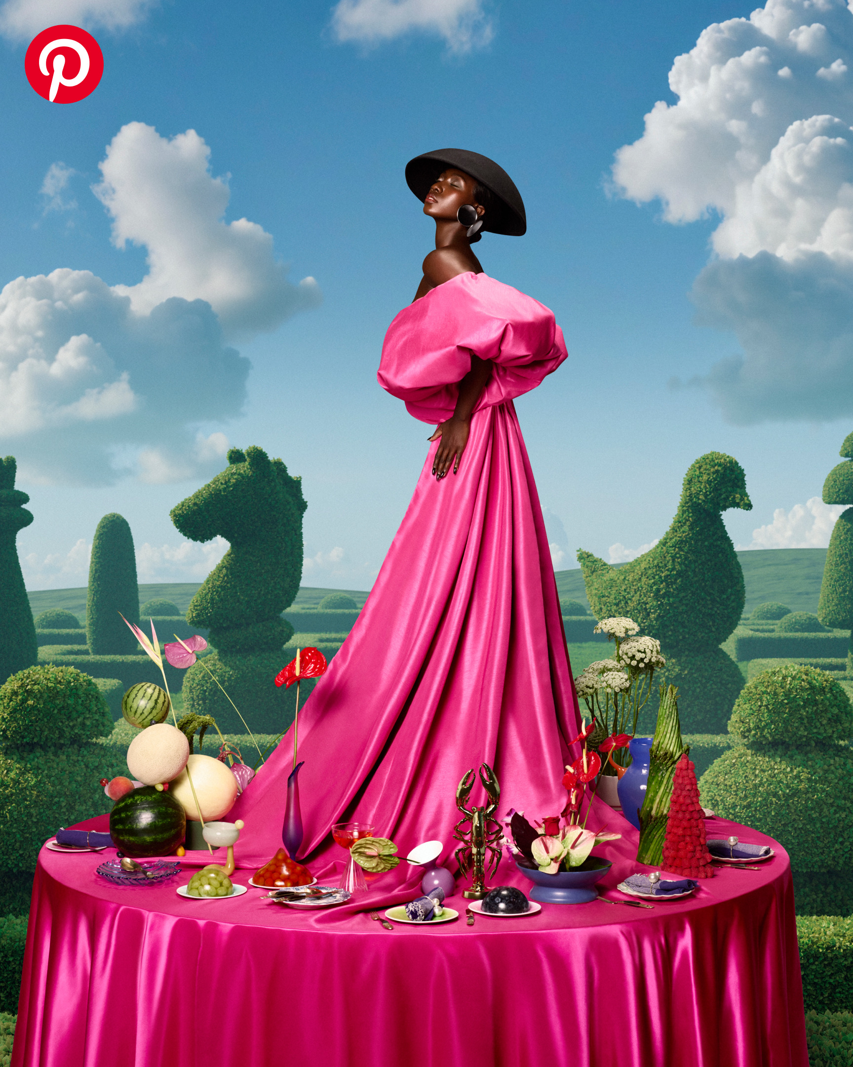 A woman in a hot pink ball gown standing on top of a brightly colored dinner party table