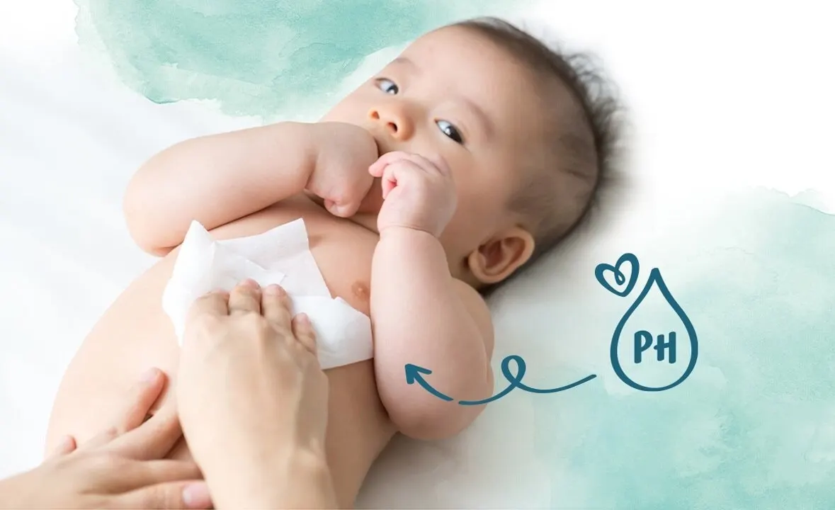 Baby das auf dem Rücken liegt wird sanft mit Pampers Sensitive Feuchttüchern sauber gemacht