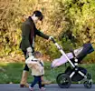 Mom walking outside with baby and toddler