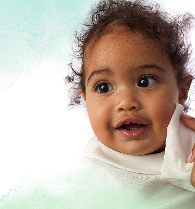 Un primer plano de la cara de un bebé mientras una mano le limpia suavemente la mejilla con una toallita Dodot Pure Calma & Protege.