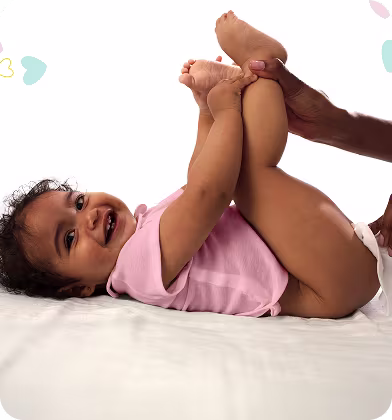 Le bébé est allongé sur le dos et est délicatement nettoyé avec une lingette humide.