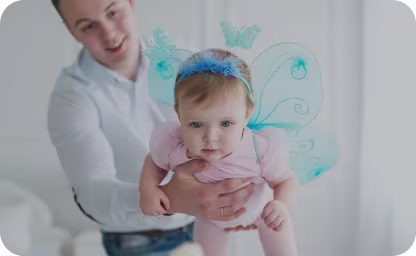 Dad holding baby dressed in pink and blue