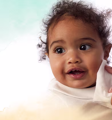 Un primer plano de la cara de un bebé mientras una mano le limpia suavemente la mejilla con una toallita Dodot Pure Cuida & Protege. Un primer plano de la cara de un bebé mientras una mano le limpia suavemente la mejilla con una toallita Dodot Pure Cuida & Protege.
