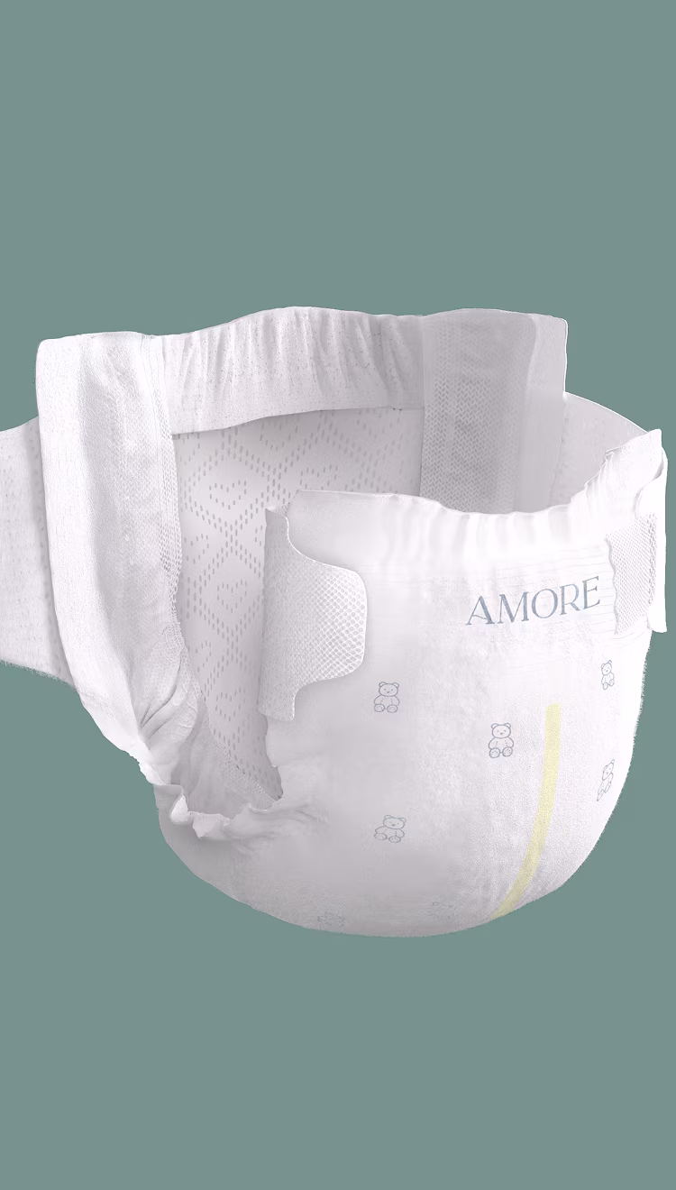 Pampers AMORE diaper on sage green background with one side open showing the inside of the diaper