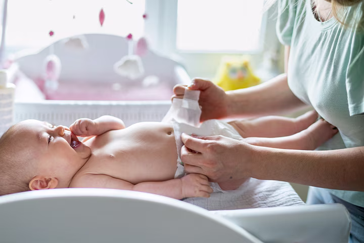 Μαμά αλλάζει την πάνα σε μωράκι