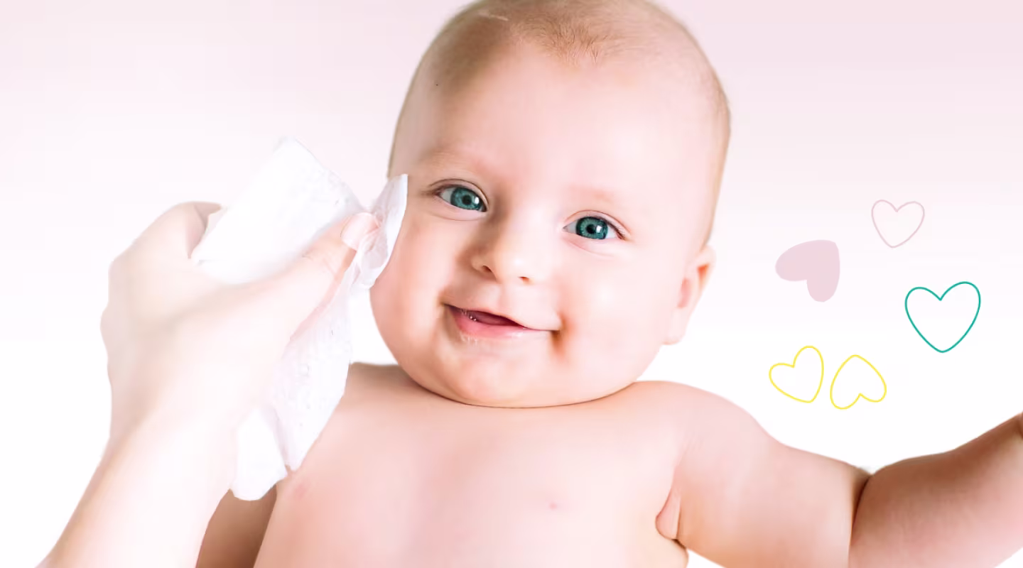 Un primer plano de la cara de un bebé mientras una mano le limpia suavemente la mejilla con una toallita Dodot.