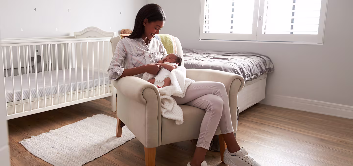 Mère tenant son nouveau-né dans ses bras, mettant en évidence les éléments essentiels pour les soins du nouveau-né.