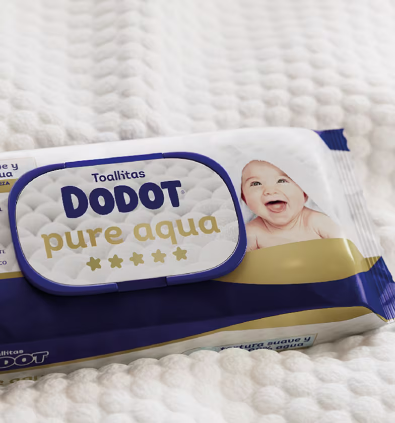 Un paquete de Dodot Pure Aqua reposa sobre una suave manta blanca texturizada.