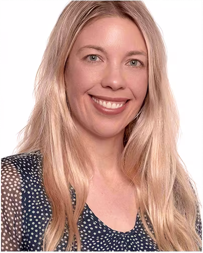 A female scientist with blonde hair and blue eyes smiles.