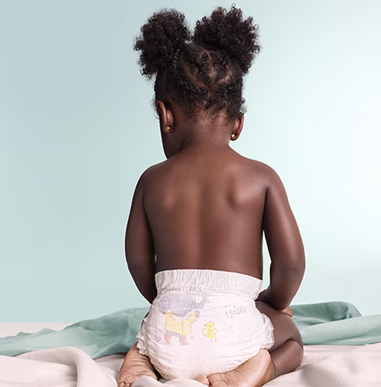 Ein Baby von hinten, das eine Premium Protection Windel trägt