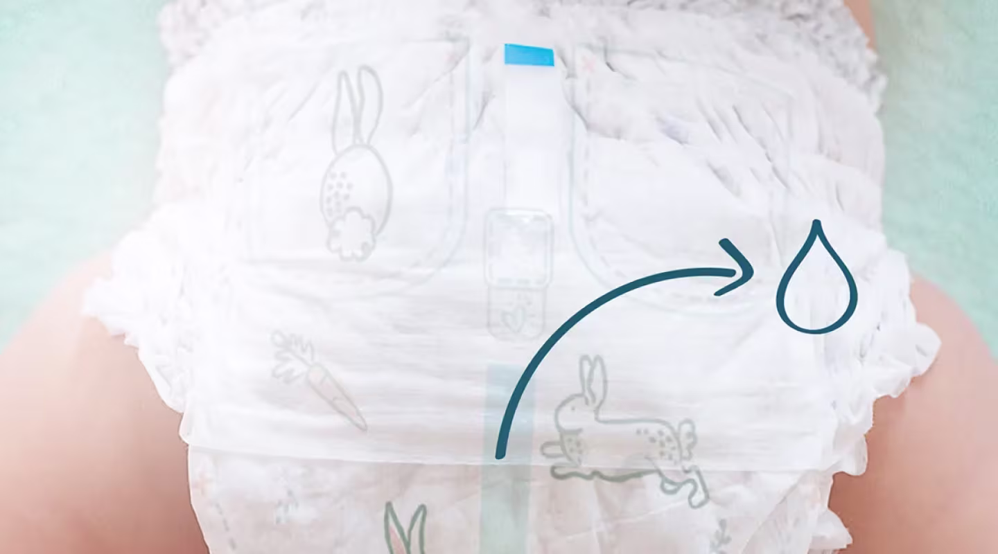 A top-down view of a baby wearing a nappy pant with a blue wetness indicator line down the center. 