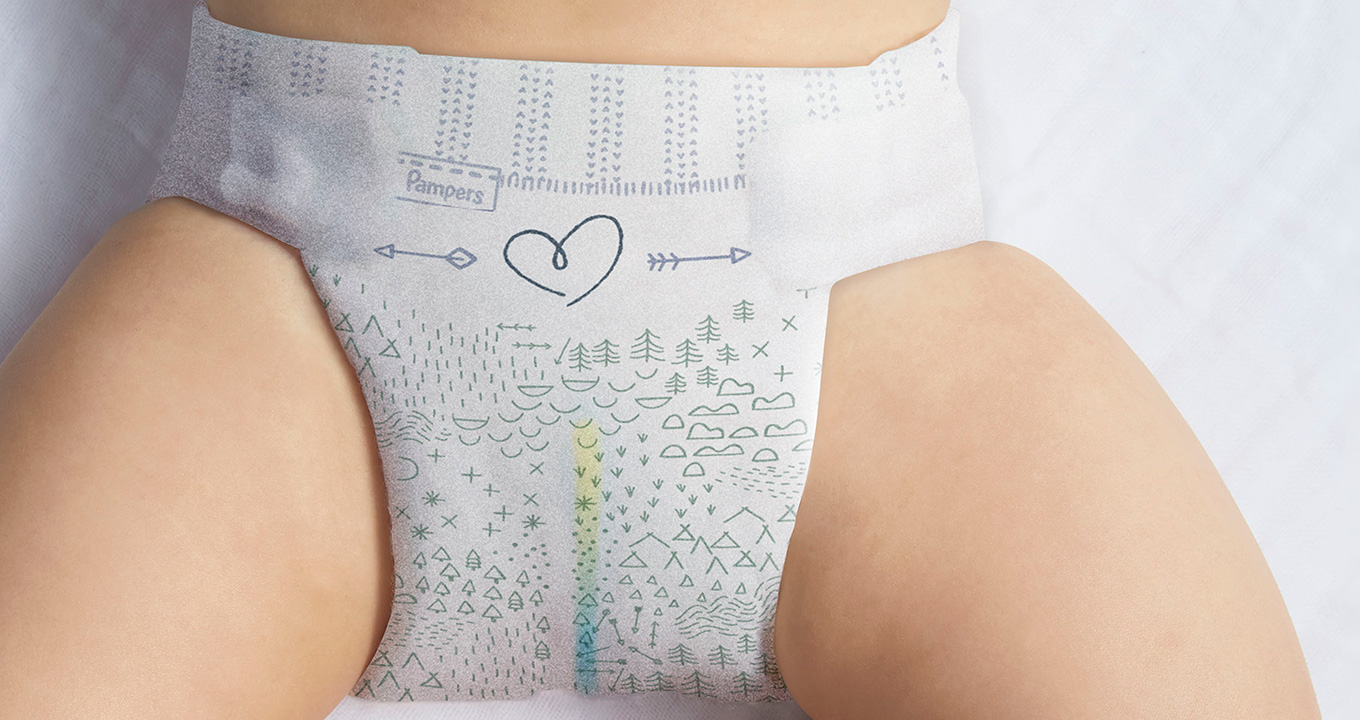 Pampers Pure Protection diaper securely fitted to a baby's legs and waist. The wetness indicator is visible from the front of the diaper, changing colour to indicate a wet diaper.
