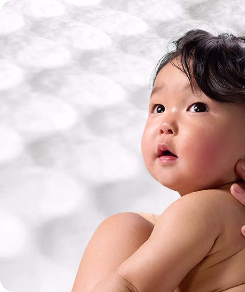 Ein Baby mit rosigen Wangen blickt