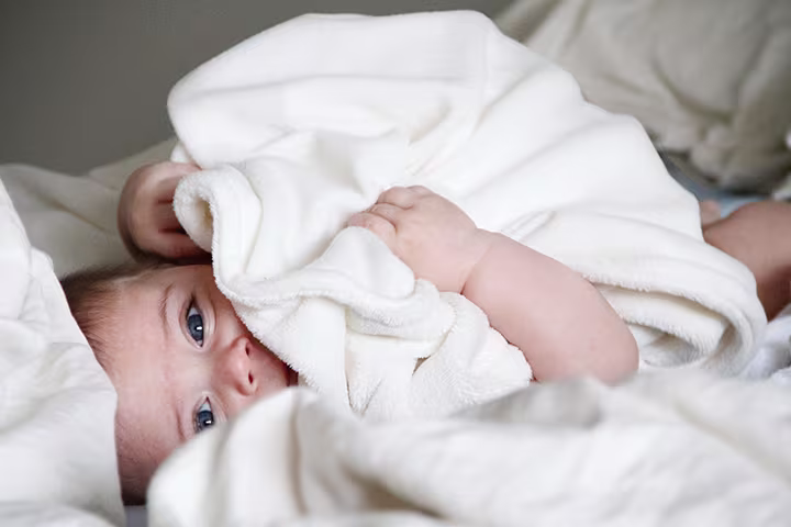 Μωρό σε κρεβάτι με κουβέρτα