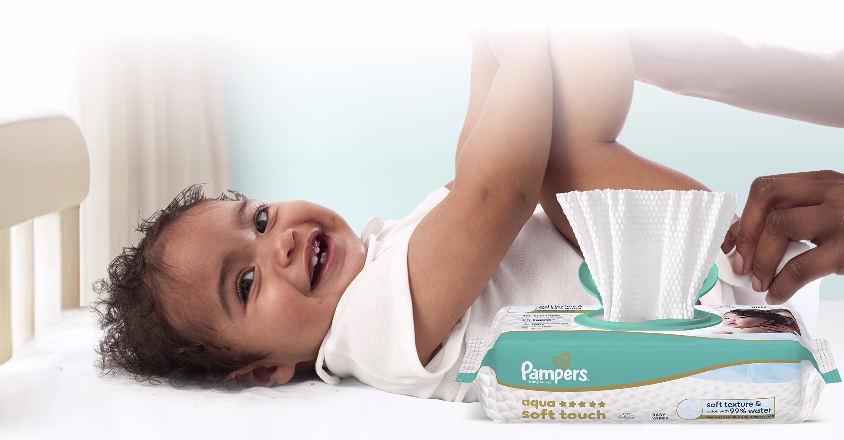 Le bébé est allongé sur le dos et est doucement nettoyé avec une lingette humide.