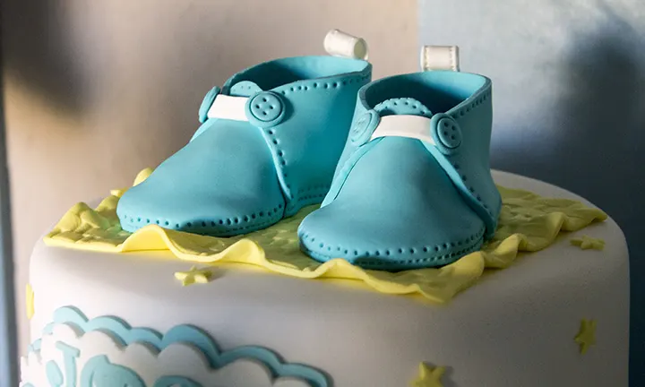 Le gâteau avec des chaussures de bébé Le gâteau avec des chaussures de bébé