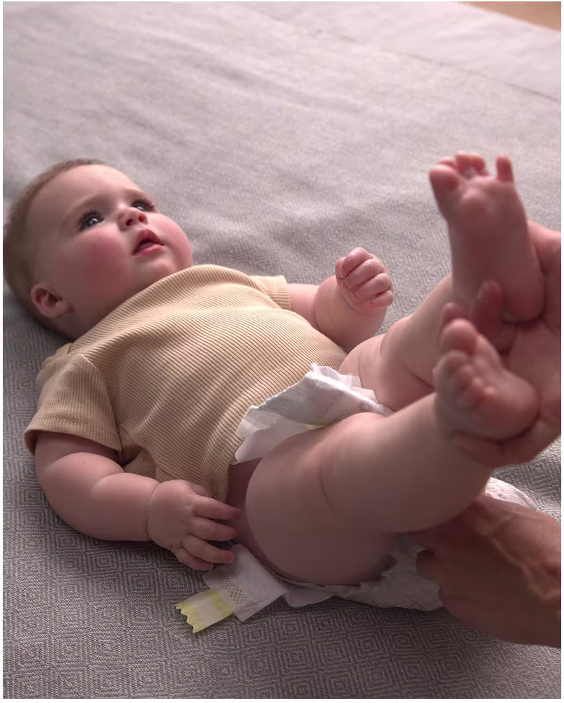 De ouders doen de luier van de baby uit