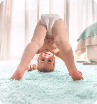 Ένα παιδί με πάνα γονατίζει, στηριζόμενο στα χέρια και στα γόνατα.