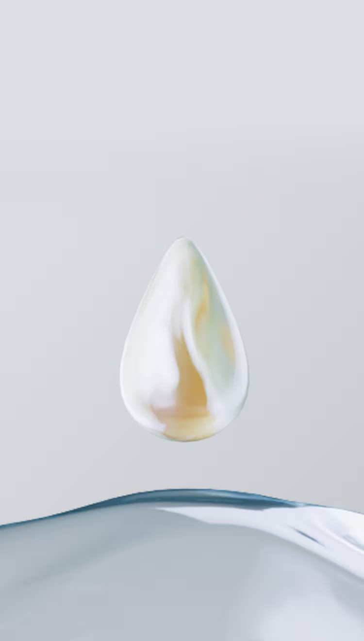 Een heldere, gouden druppel lotion zweeft boven een druppel helder en puur water.