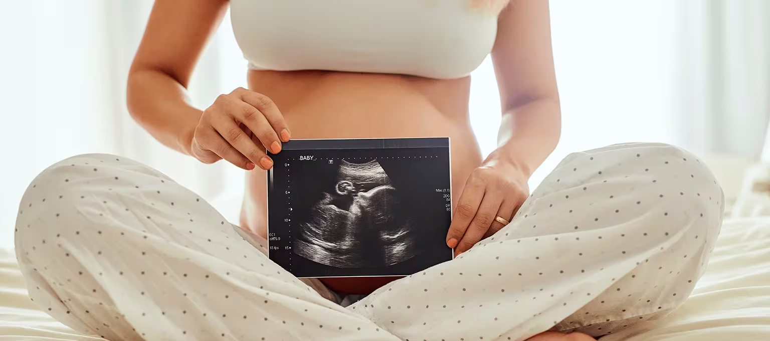 Mamá con resultados de ecografía en el embarazo