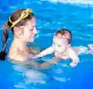 Bebê usando fraldas para nadar com a mamãe na piscina