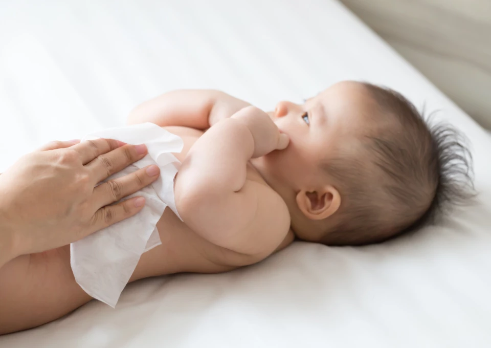 Mamá limpiando a su bebé con toallitas húmedas