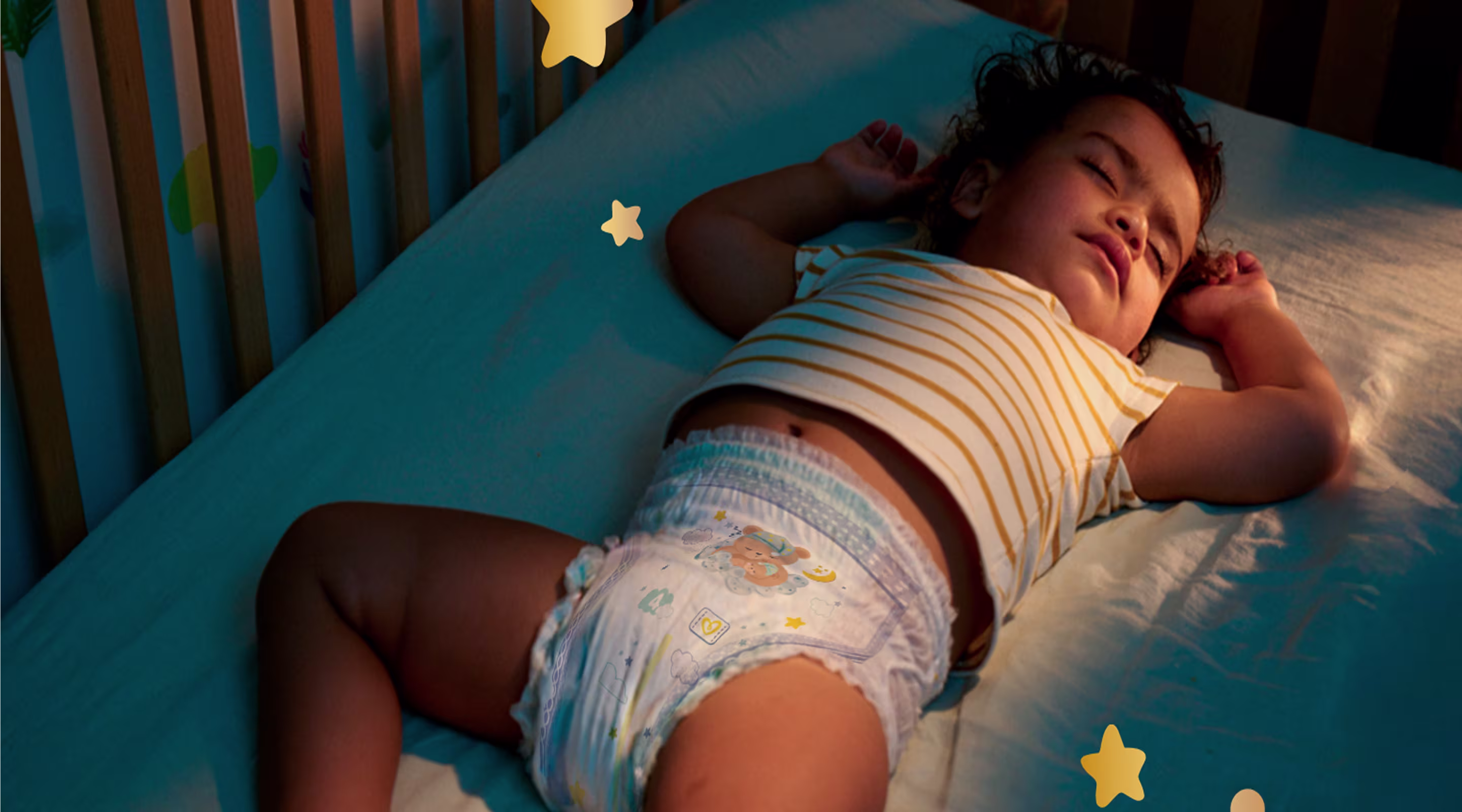 Een baby slaapt rustig op zijn rug en draagt een Pampers® Night Pants met nachtelijke motieven.