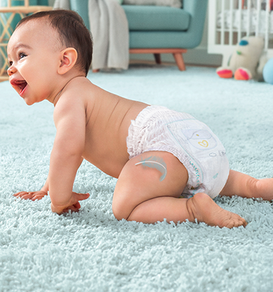 Bebé sonriente y gateando con un pañales-braguita Dodot
