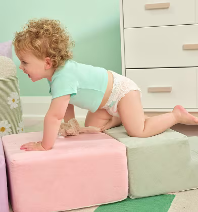 Bebé gateando sobre bloques suaves mientras usa Pampers Cruisers360