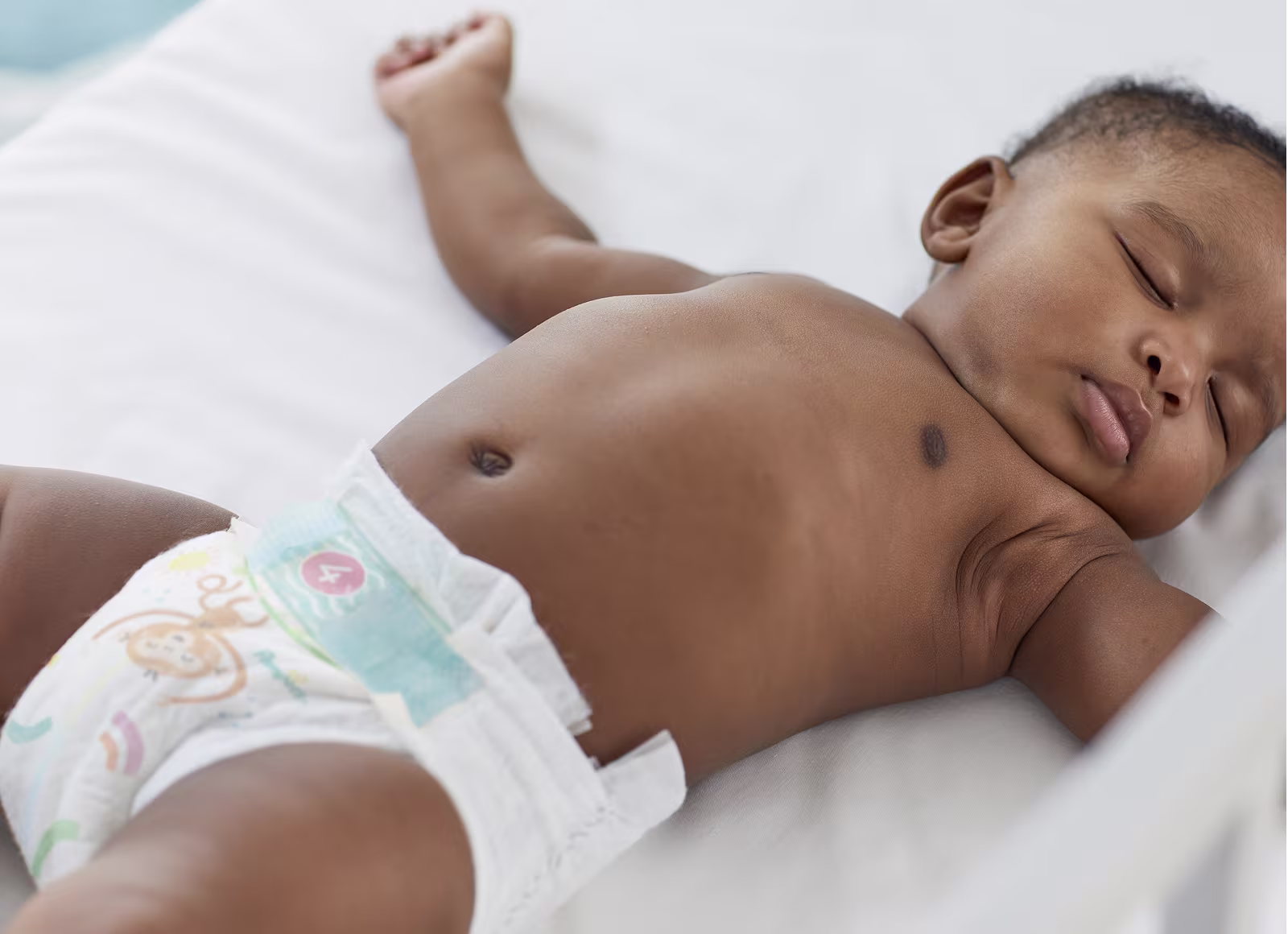 Een baby slaapt op zijn rug in een Pampers Baby-Dry luier