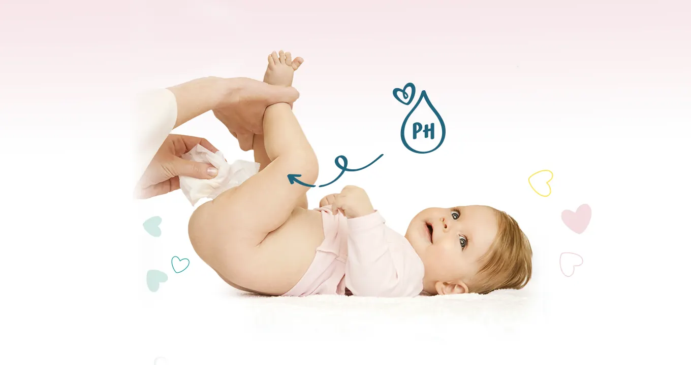 Un bebeluș este întins, iar două mâini îi ridică piciorușele pentru a-l curăța cu un șervețel umed. Există o pictogramă în formă de picătură, în interiorul căreia apare cuvântul «pH».