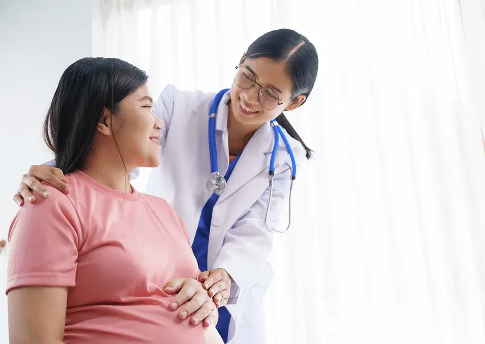 Doctora revisando a mujer embarazada con preeclampsia