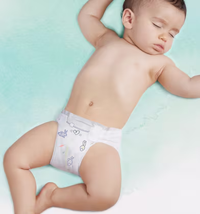 Zdjęcie pokazuje dolną część tułowia i nogi niemowlęcia leżącego na jasnooliwkowej powierzchni w pieluszce Pampers, która ma elastyczny pasek i ładne rysunki. Zdjęcie pokazuje dolną część tułowia i nogi niemowlęcia leżącego na jasnooliwkowej powierzchni w pieluszce Pampers, która ma elastyczny pasek i ładne rysunki.