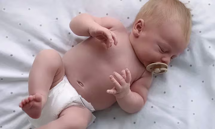 Banner image of newborn baby with a pacifier