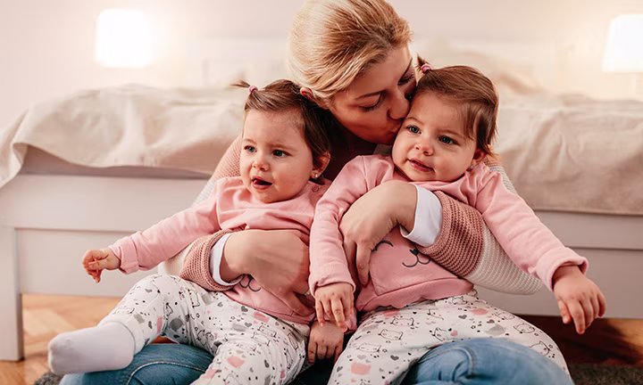 Frau hält Zwillinge im Arm