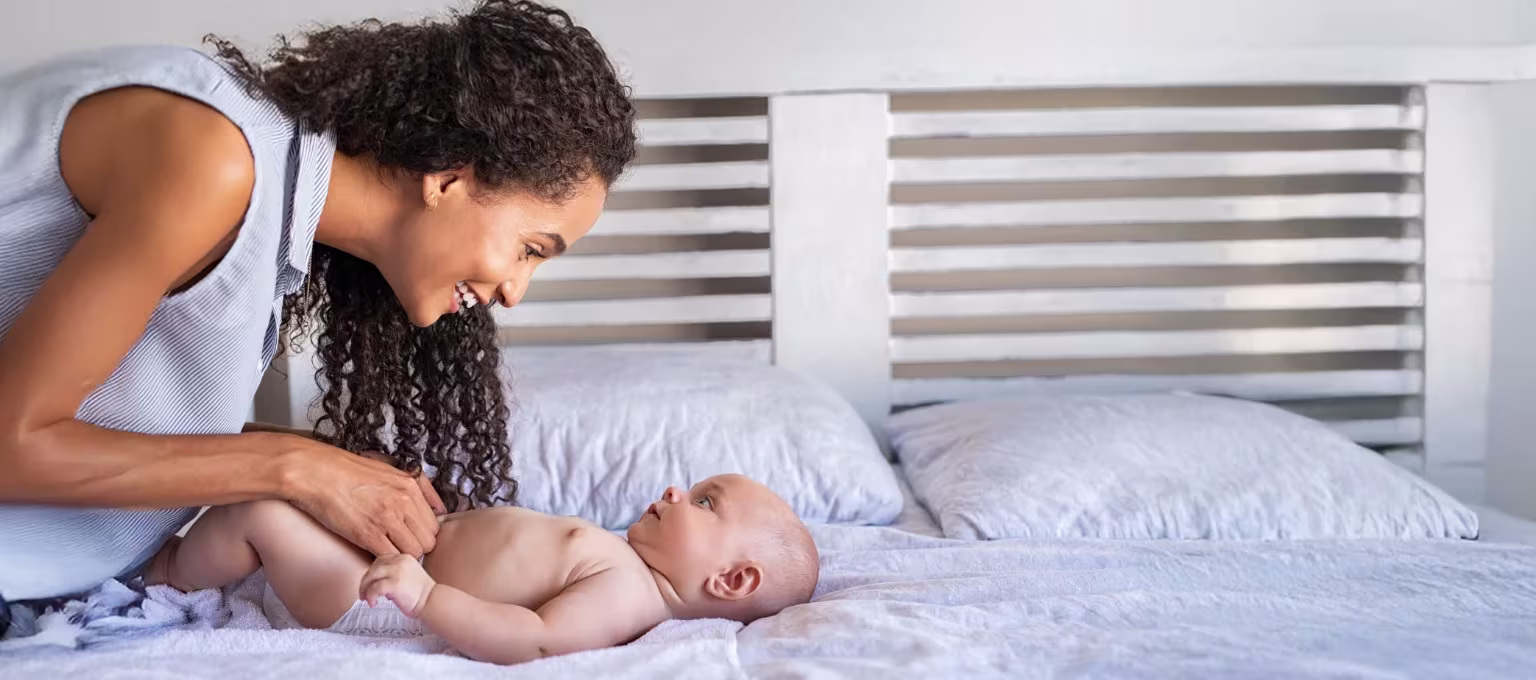 Mamá cambiando pañal a su bebé