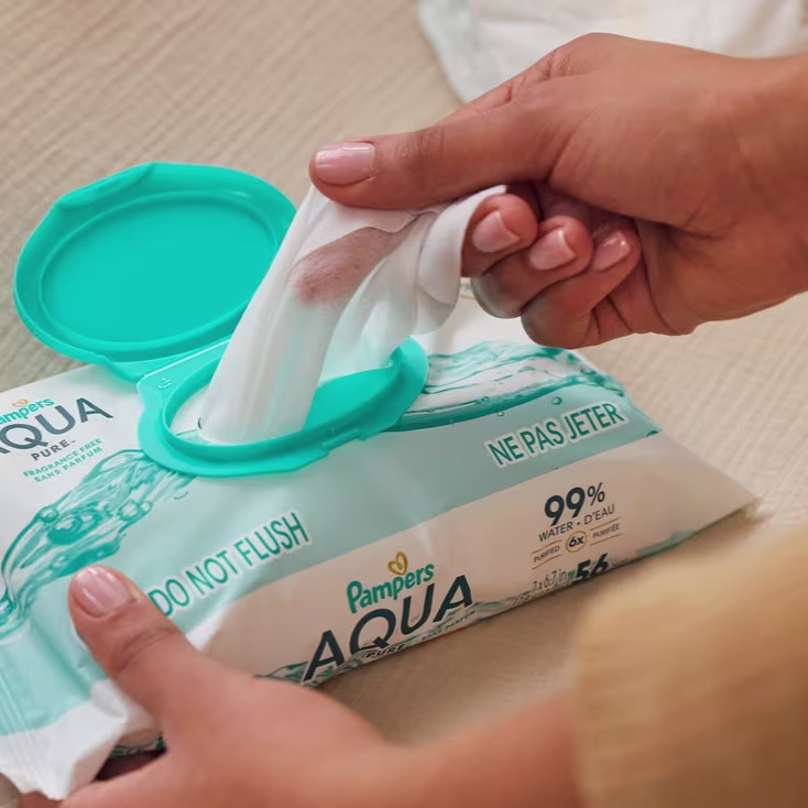 Mom pulling a Pampers Aqua Pure wipes out of the pack Mom pulling a Pampers Aqua Pure wipes out of the pack