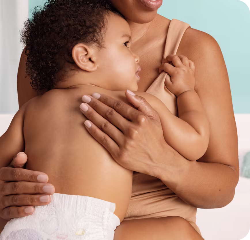 Eine Mutter hält ihr Baby fest auf dem Schoß