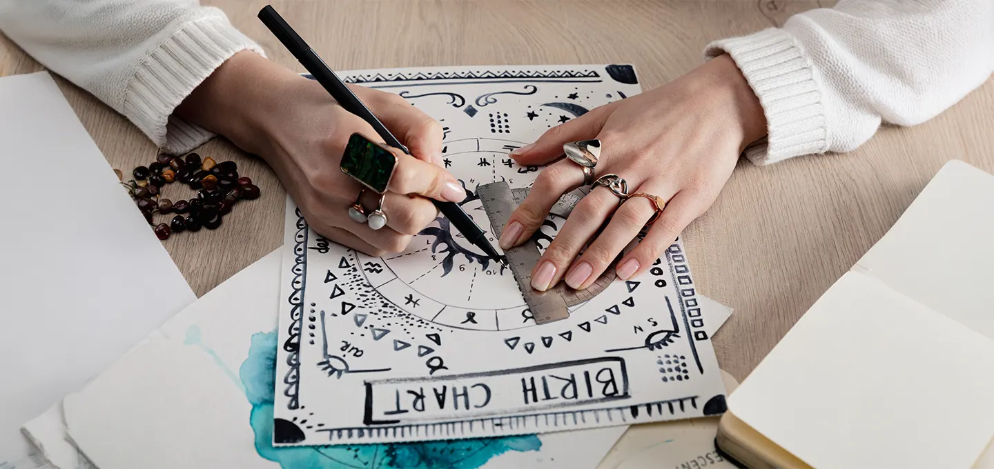 Hands drawing on a zodiac birth chart