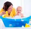 Mamá bañando a su pequeño en bañera para bebé.