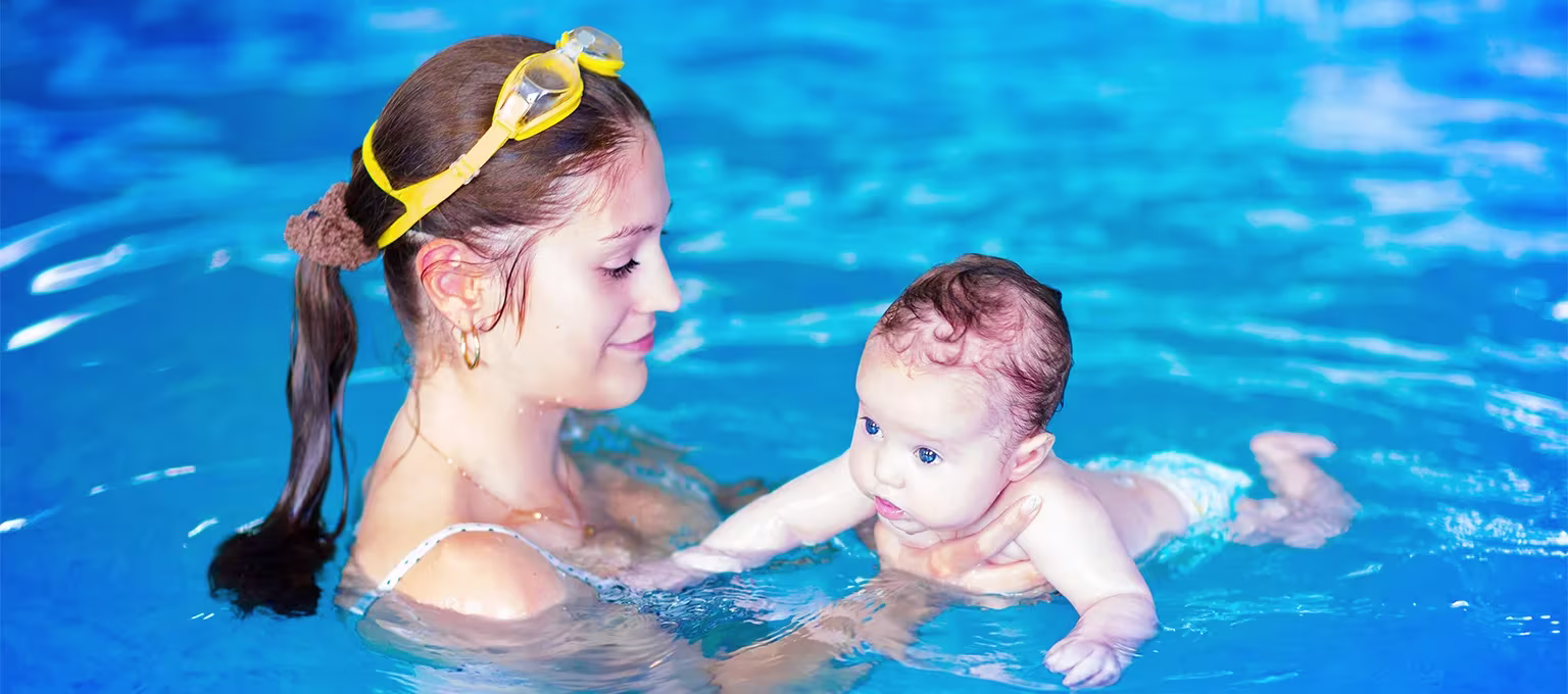 Bebé nadando con su mamá con pañales para alberca