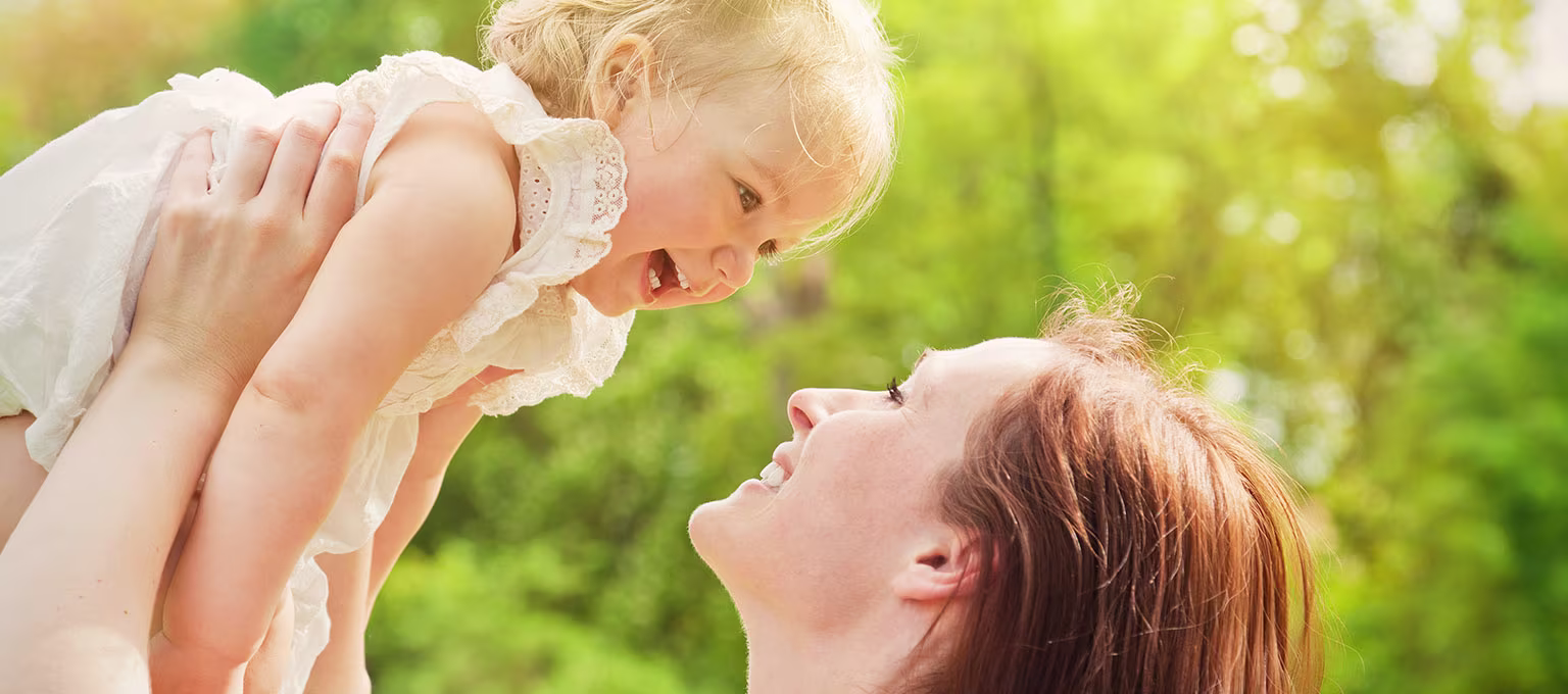 Mother holds baby in the park