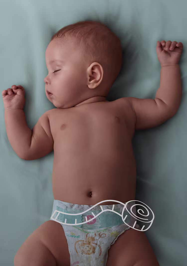 Baby slaapt in het bed, met een regel over de maat van de luier.