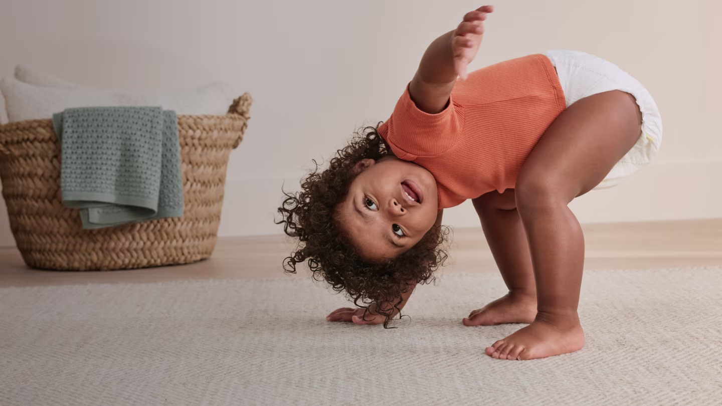 Toddler playing in nursery showing the flexible fit of a Pampers diaper
