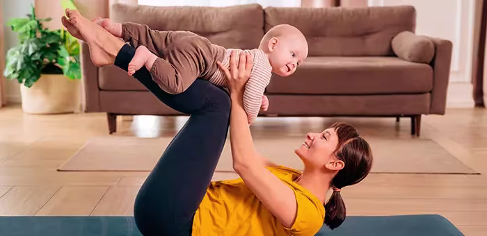 Mamá haciendo ejercicios posparto con su bebé