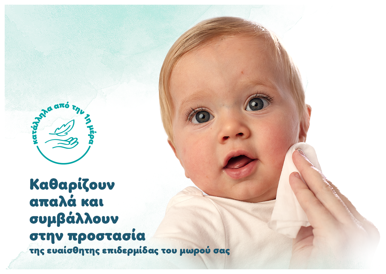 Σε ένα μωράκι ένα χέρι ακουμπάει ένα μωρομάντηλο στο αριστερό του μάγουλο. Αναγράφονται τα κείμενα: «Καθαρίζουν απαλά και συμβάλλουν στην προστασία της ευαίσθητης επιδερμίδας του μωρού σας
και Κατάλληλα από την πρώτη μέρα».