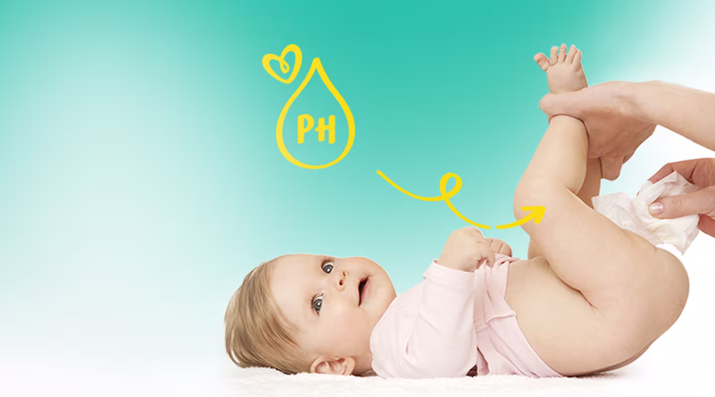 Ένα μωρό είναι ξαπλωμένο ανάσκελα ενώ ένα άτομο σκουπίζει τον ποπό του μωρού με ένα μωρομάντηλο.