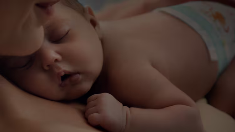 Dziecko śpiące na klatce piersiowej swojej mamy